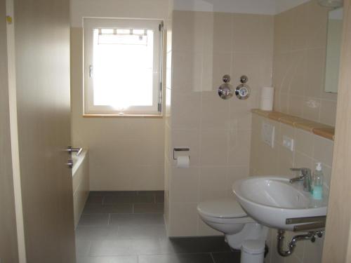a bathroom with a sink and a toilet and a window at Appartements Vanii in Rust