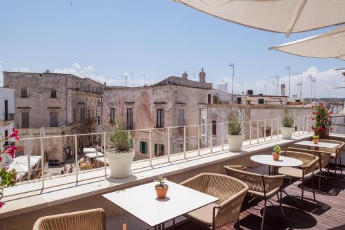 a balcony with tables and chairs and buildings at Sei Stelle Mama in Polignano a Mare