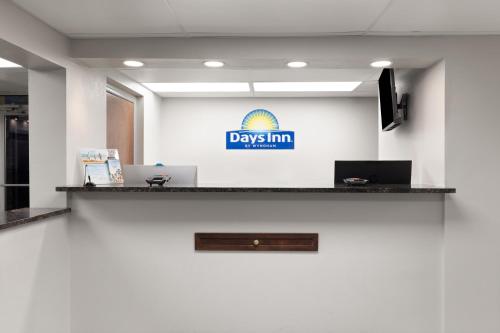 an office with a desk with a day inn sign on the wall at Days Inn by Wyndham Harrisonburg in Harrisonburg