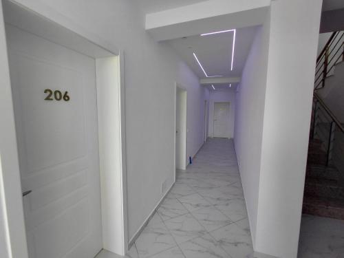 an empty hallway with white walls and a number on the wall at Vila Kasemi in Fier