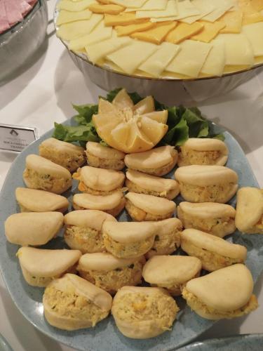 a plate of food with cheese and a pie at Camaçari Plaza Hotel in Camaçari