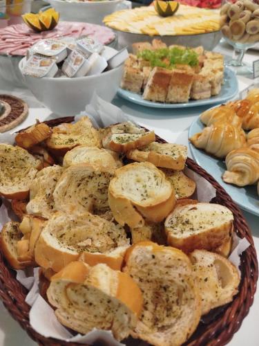 a table topped with plates of bread and other foods at Camaçari Plaza Hotel in Camaçari