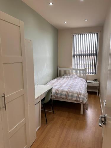 リバプールにあるByrom House Apartmentsのベッドと机と窓のある寝室