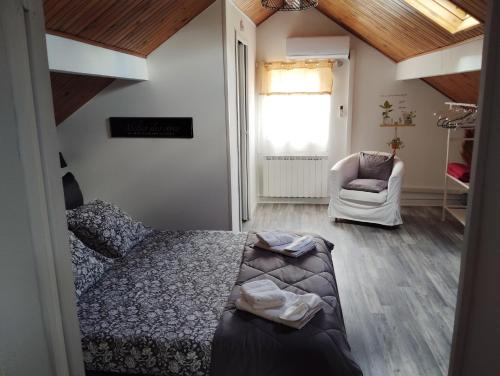 une chambre avec un lit, une chaise et une fenêtre dans l'établissement Chambre d'hôtes à mouleydier, à Mouleydier