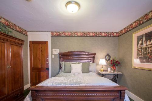 a bedroom with a bed with a wooden headboard at Stroudsmoor Country Inn in Stroudsburg