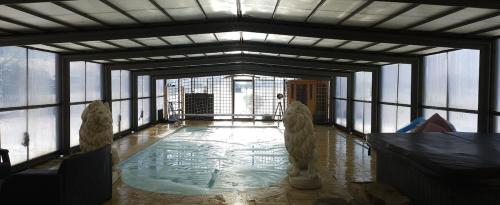 Cette chambre avec piscine se trouve dans un bâtiment doté de fenêtres. dans l'établissement Villa avec piscine et jacuzzi privé, à Saint-Clair-dʼArcey
