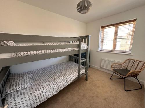 a bedroom with two bunk beds and a chair at Holiday home in Holt in Holt