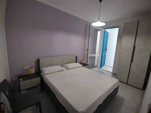 a bedroom with a white bed and a window at Appartamento Mozart 3 a Pescoluse in Marina di Pescoluse