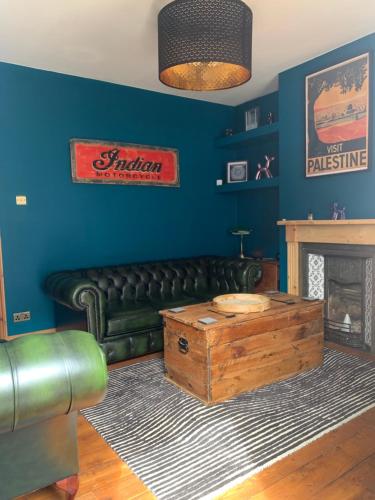 a living room with a leather couch and a fireplace at Stunning Beach house in Gorleston-on-Sea