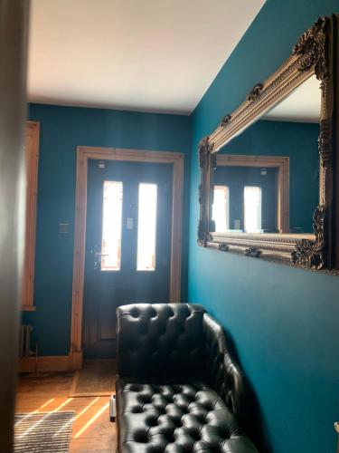 a room with a black leather chair and a mirror at Stunning Beach house in Gorleston-on-Sea