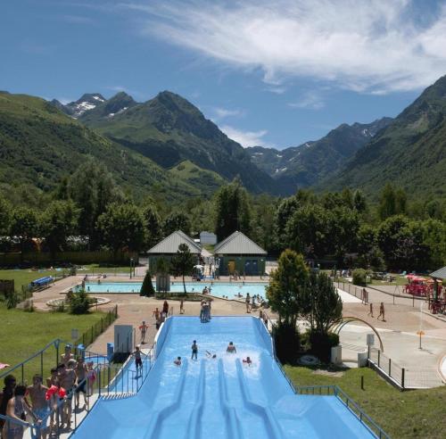 a large swimming pool with people at a resort at grange rénovée en gîte/maison/chalet in Arreau