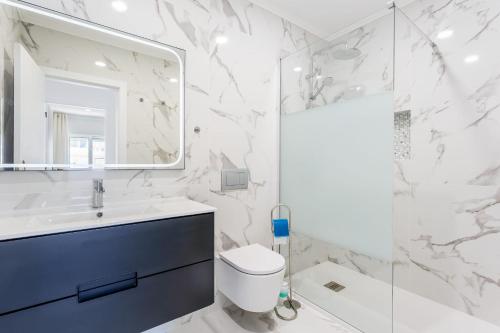 a bathroom with a toilet and a sink and a mirror at Bright 2BDR Flat in Armação de Pêra by LovelyStay in Armação de Pêra