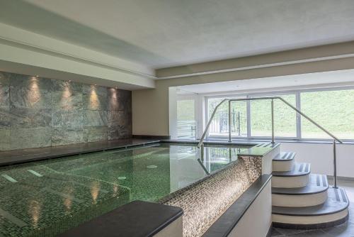 an indoor swimming pool with a glass floor at Hotel Garnì Paradisi - Wellness & Spa in Mezzano