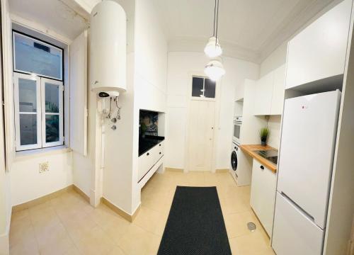 a kitchen with white cabinets and a black rug at Luxury rooms in the centre of Lisbon, Alfama in Lisbon