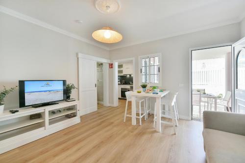 a living room with a television and a table at Casa Nena by VillaGranCanaria in Playa del Ingles