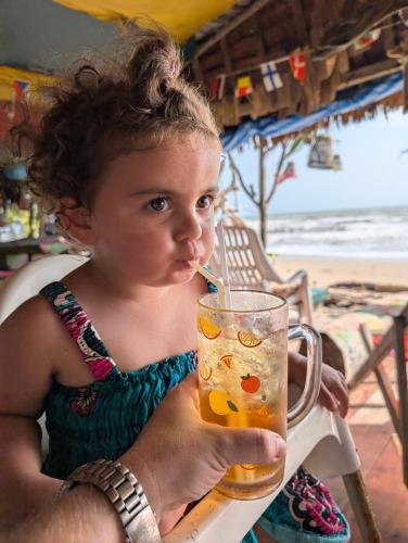 a little girl drinking from a glass with a straw at Scandinavian Beach Resort in Ko Lanta