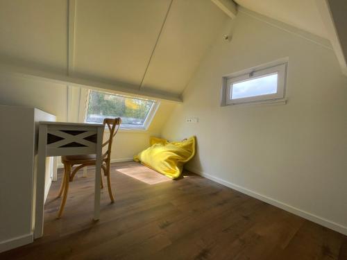 a room with a desk and a yellow pillow at Chocolat & Vanille in Koksijde