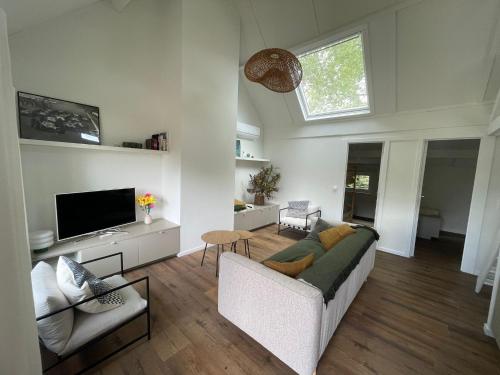 un soggiorno con un divano e una TV di Chocolat & Vanille a Koksijde