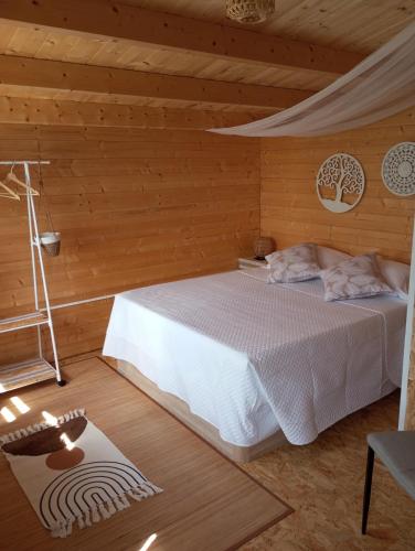 a bedroom with a bed in a wooden cabin at Nüa Relax in San Vicente de Calders