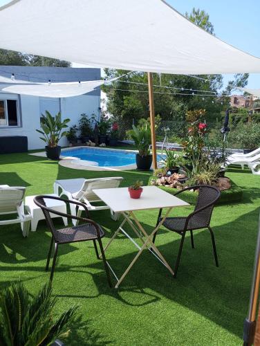 a white table and chairs under a white umbrella at Nüa Relax in San Vicente de Calders