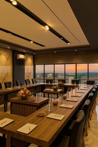 a large dining room with tables and chairs and windows at Bona Ventura Hotel & Skybar in Tanjung Pinang 