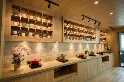 a kitchen with a counter with pots and pans at Unya Hotel Ubon - โรงเเรมอัญญาอุบล in Ban Na Khwai