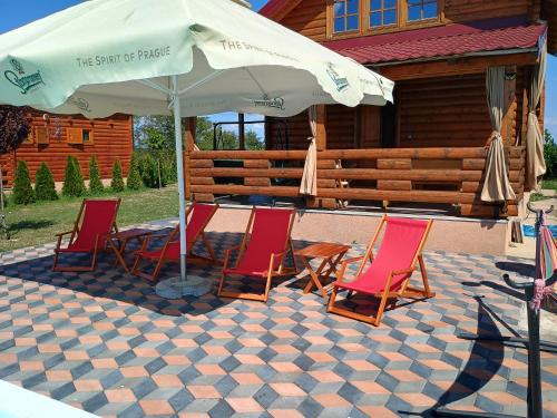 a group of chairs and an umbrella on a patio at Vikendica sa bazenom Čarolija Kruševac in Kruševac