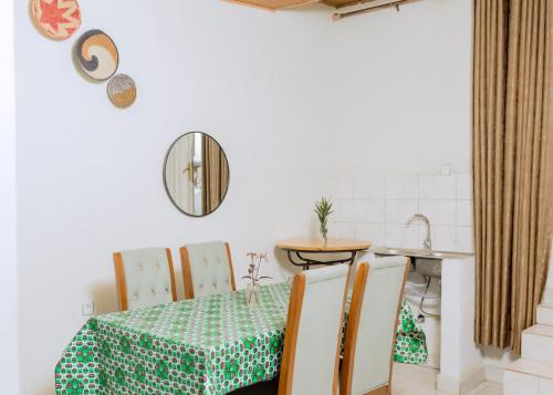 a dining room with a table and chairs and a mirror at Hi-Pima Boutique Hotel in Kigali