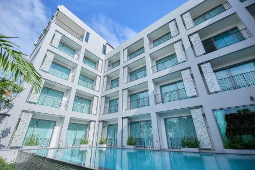 an apartment building with a swimming pool at Unya Hotel Ubon - โรงเเรมอัญญาอุบล in Ban Na Khwai