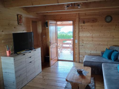 a living room with a couch and a flat screen tv at Vikendica sa bazenom Čarolija Kruševac in Kruševac