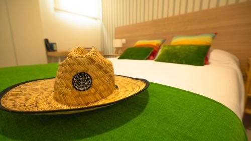 a straw hat sitting on top of a bed at Apartamentos Costa Norte in San Vicente de la Barquera