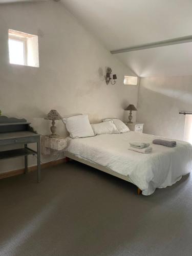 a white bedroom with a bed and a desk at LA CROIX DES GRANGES in Chapdeuil