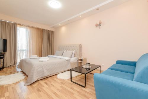 a bedroom with a bed and a blue couch at ERA RENT Apartments in Chişinău