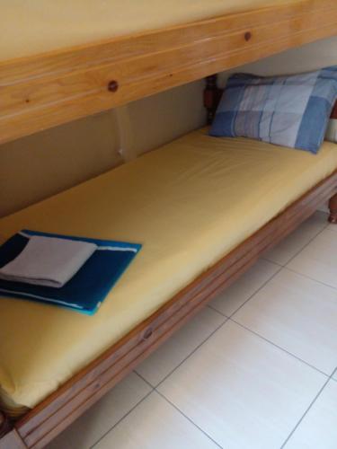 a bed with a wooden frame and a pillow on it at Ofellows - Kristal Center in Tirana