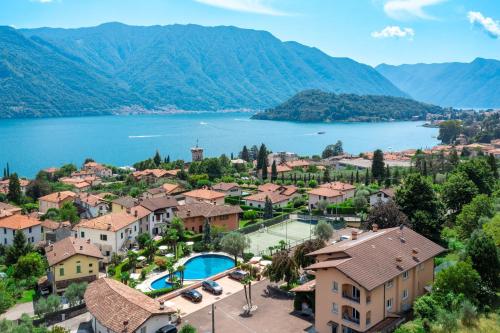 a resort with a lake and mountains in the background at Albergo Villa Edy in Tremezzo