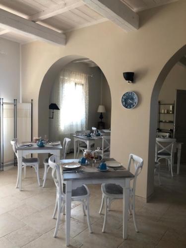 a dining room with two tables and white chairs at Agriturismo Tenuta il Molino in Gabbro