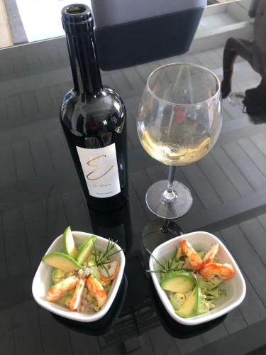 a bottle of wine and a bowl of shrimp and a wine glass at Agriturismo Tenuta il Molino in Gabbro