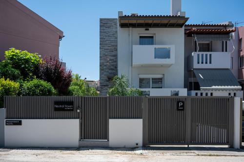a fence in front of a house with a building at Neutral Haven in Nafplio