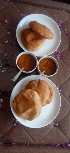 three plates of food on a table with bowls of food at PARK VIEW GUEST HOUSE in Leh