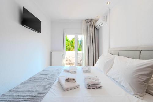 a bedroom with a white bed with towels on it at Sonia's Maison in Limenas