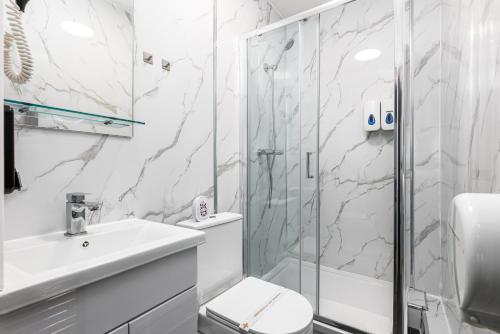 a bathroom with a shower and a toilet and a sink at City Gate Guest House in London