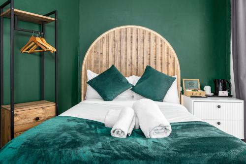 a bedroom with a large bed with green walls at City Gate Guest House in London