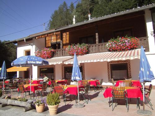 a restaurant with tables and chairs and umbrellas at Ferienwohnung Kirchbrücke in Mieders