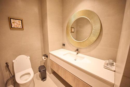 a bathroom with a sink and a toilet and a mirror at Unya Hotel Ubon - โรงเเรมอัญญาอุบล in Ban Na Khwai