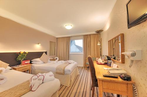 オーバンにあるMuthu Queens Hotel, Obanのベッド2台と机があるホテルの部屋