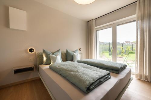a bedroom with a bed with a large window at Villa Sawian in Appiano sulla Strada del Vino