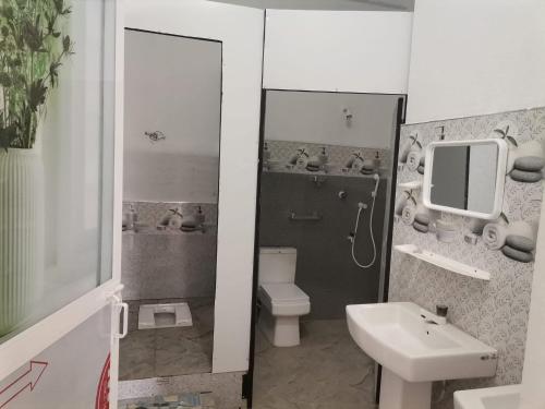 a bathroom with a toilet and a sink and a mirror at MarHab Hotel Apartment in Pottuvil