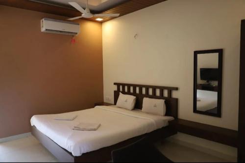 a bedroom with a bed with a fan and a mirror at Leela beachside stay in Kashid