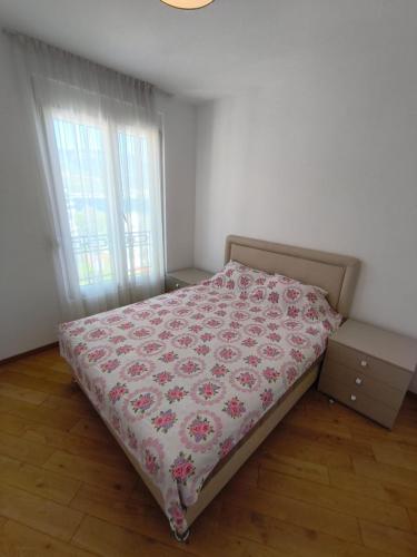 a bedroom with a bed with a flowered blanket at Sea view Chiron in Budva