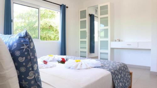 a bedroom with a bed with pillows and a window at Maison Marie Jeanne - Unit 1 in Baie Sainte Anne